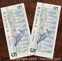 Reverse side of both notes showing Belted Kingfisher and serial numbers