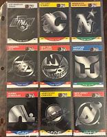 Front view of nine silver-on-black team logo cards in binder page