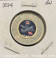 Reverse view of coin in holder showing aircraft design and dates