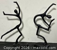 Front view of both black metal dancer sculptures