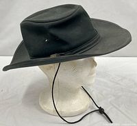 Side profile of dark green outback hat on mannequin displaying overall shape and chin cord