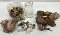 Overall lot showing jar, plastic tub, large jasper block, loose rough stones and cabochons