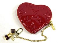 Front view of red heart-shaped Monogram Vernis coin purse with gold chain and charms