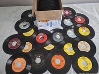 Top view of box and spread-out 45s showing labels Columbia, Epic, RCA Victor, Mega, etc.