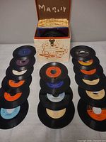 Overall lot showing storage case and two rows of 45 RPM records