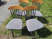 All four dining chairs grouped together on grass