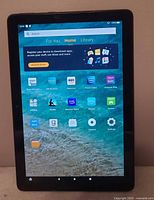 Front view of tablet powered on displaying home screen