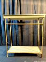 Front view of two-tier accent table showing sage panels and gold frame