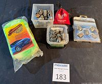 Overview of both wheel nut sets in bins, locking nuts in pouch and blister pack