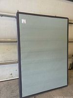 Front view of full-size box spring showing light green top fabric and dark grey border