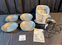 Overall lot: four cake pans, Oster mixer, case, attachments, manual