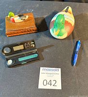 Group view of ceramic coin bank, travel alarm clock, wooden card box with decks