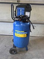 Full view of blue 20-gallon air compressor with gauges, handle, wheels and power cord