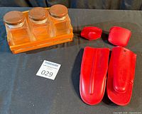 Overview of entire lot showing glass jars in caddy and red silicone mitts/pot holders