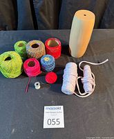All items grouped: yarn holder, six thread balls, two cord hanks, small spool