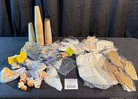 Full lot overview on tabletop showing cones, bagged doll parts, wings, leaves