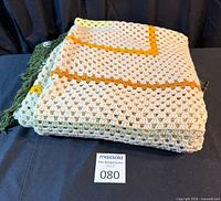 Folded crochet blanket on table showing texture and color pattern