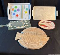 Group shot of all five items: two trays, two cutting boards, one plate