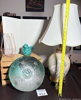 Group view showing lamp, glass bowl, candle holder, ceramic bird