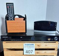 Front view of Samsung DVD player with remote caddy and alarm clock on top