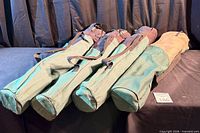 Four cylindrical fabric carry bags laid side by side