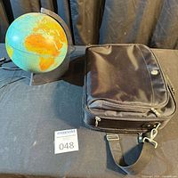 Globe lit and briefcase closed on table