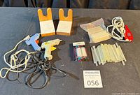 Lot overview showing glue guns, stands, glue sticks, engraver