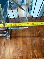 Tape measure across glass top showing length about 49 inches