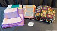 Three folded crochet blankets side by side