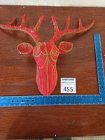 Front view of red and green fabric deer head with antlers