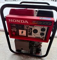 Front view showing Honda EM3000C label and control panel with outlets and ratings