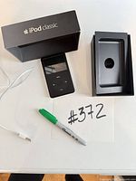 Complete lot showing iPod Classic, USB cable, booklet, and box components