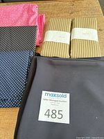 Overview of all fabric pieces: pink, navy, black, two beige striped bundles