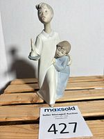 Front view of Lladro figurine on wood slats with auction tag visible