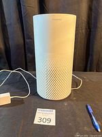 Front view showing cylindrical body, perforations, power cord