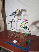 Both metal bird sculptures on tabletop for scale