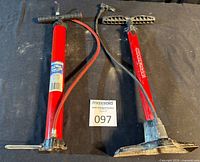 Both red floor pumps side by side showing overall condition