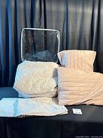 Stack showing quilt, two dusty rose pillow shams, two accent pillows