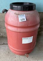 Full view of red rain barrel with black lid and spigot