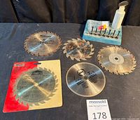 Group view of five saw blades with glue spreading kit tray and bottle