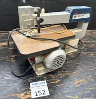 Front and left side view of Ryobi SC160 scroll saw showing table, blade guard and motor housing