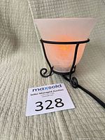 Lamp lit showing frosted swirl glass shade and metal scroll base