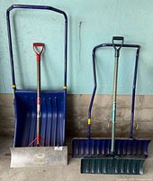 All four snow removal tools standing against wall