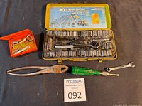 All items laid out: 40-piece socket set open, mini set closed, pliers, screwdriver, wrench