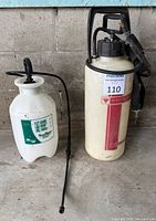 Both sprayers side by side showing complete tanks, handles, wands and strap