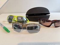 Three pairs of sunglasses and case on table