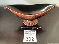 Side view of Beswick boat-shaped pedestal bowl with black interior and drip glaze exterior