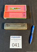 Hohner Echo Harp harmonica with open case, auction lot card and pen for scale