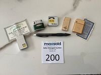 Group shot showing all five lighters, Yellow Pages tape measure, Zippo guarantee slip and Hinton guarantee card