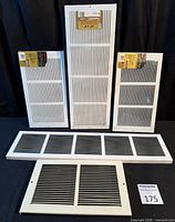 All five white steel wall grilles displayed, three in packaging, two loose